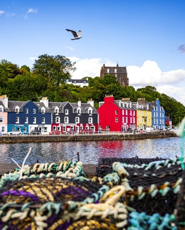 The colourful houses at Tobermory harbour on the Isle of Mull, with fishermens creels in the foreground.