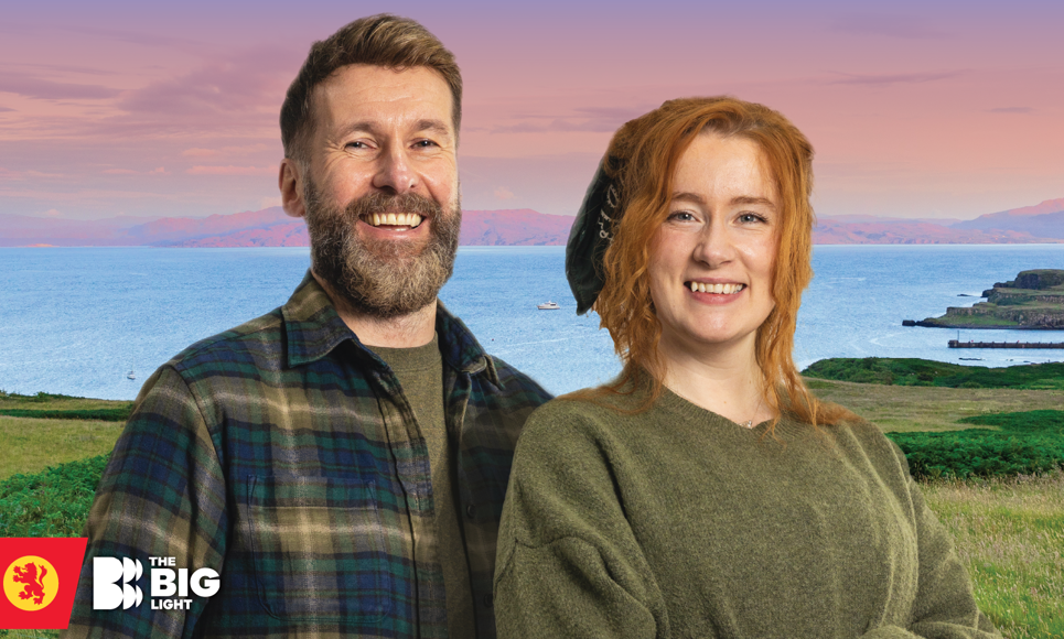 The Hebridean Baker and Nati Galloway standing outdoors with a scenic coastal landscape behind them.