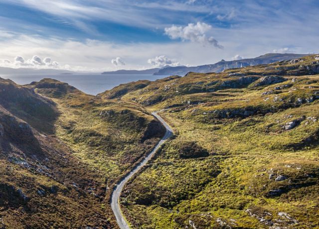 An aerial view of Calums road winding its way up the hilly landscap3 of Raasay.